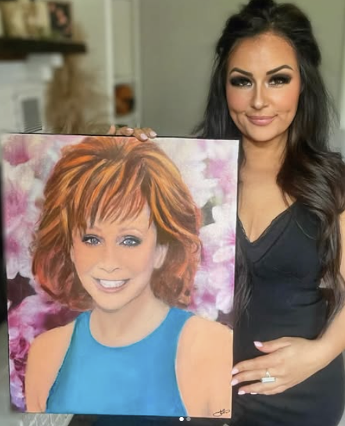Tess Frizzell posing with a painting